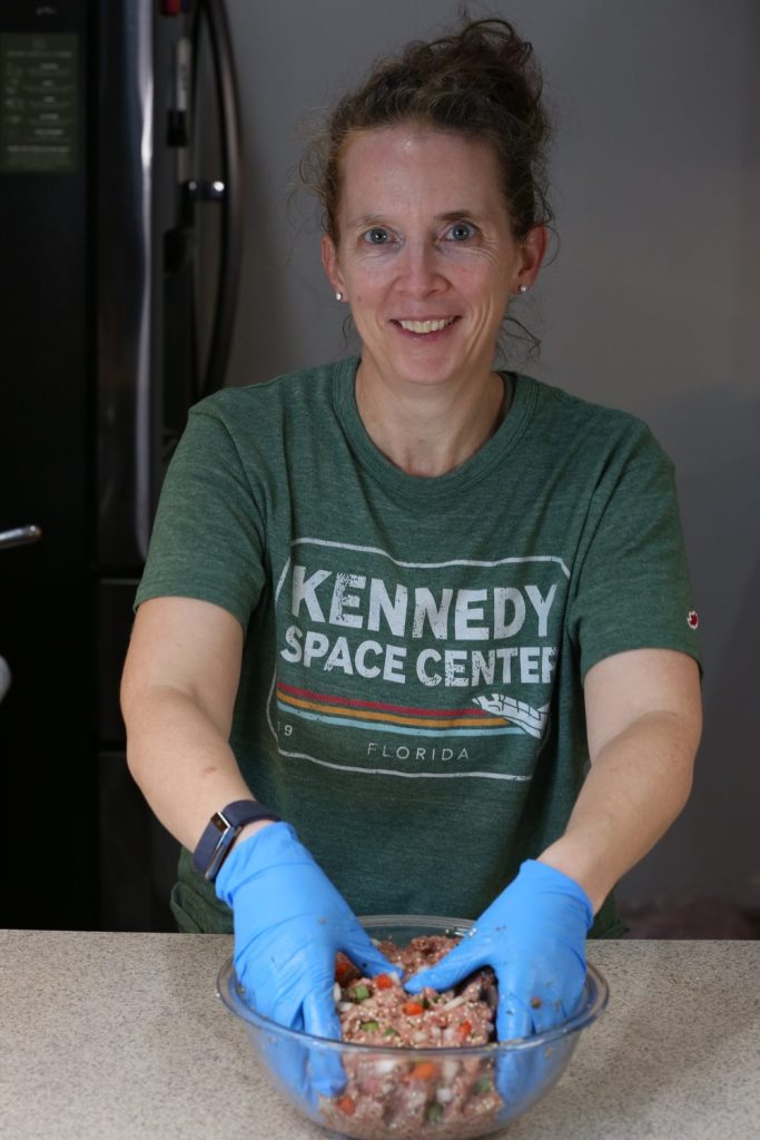 Erin, founder of The Perennial Kitchen, mixing meatloaf in her kitchen